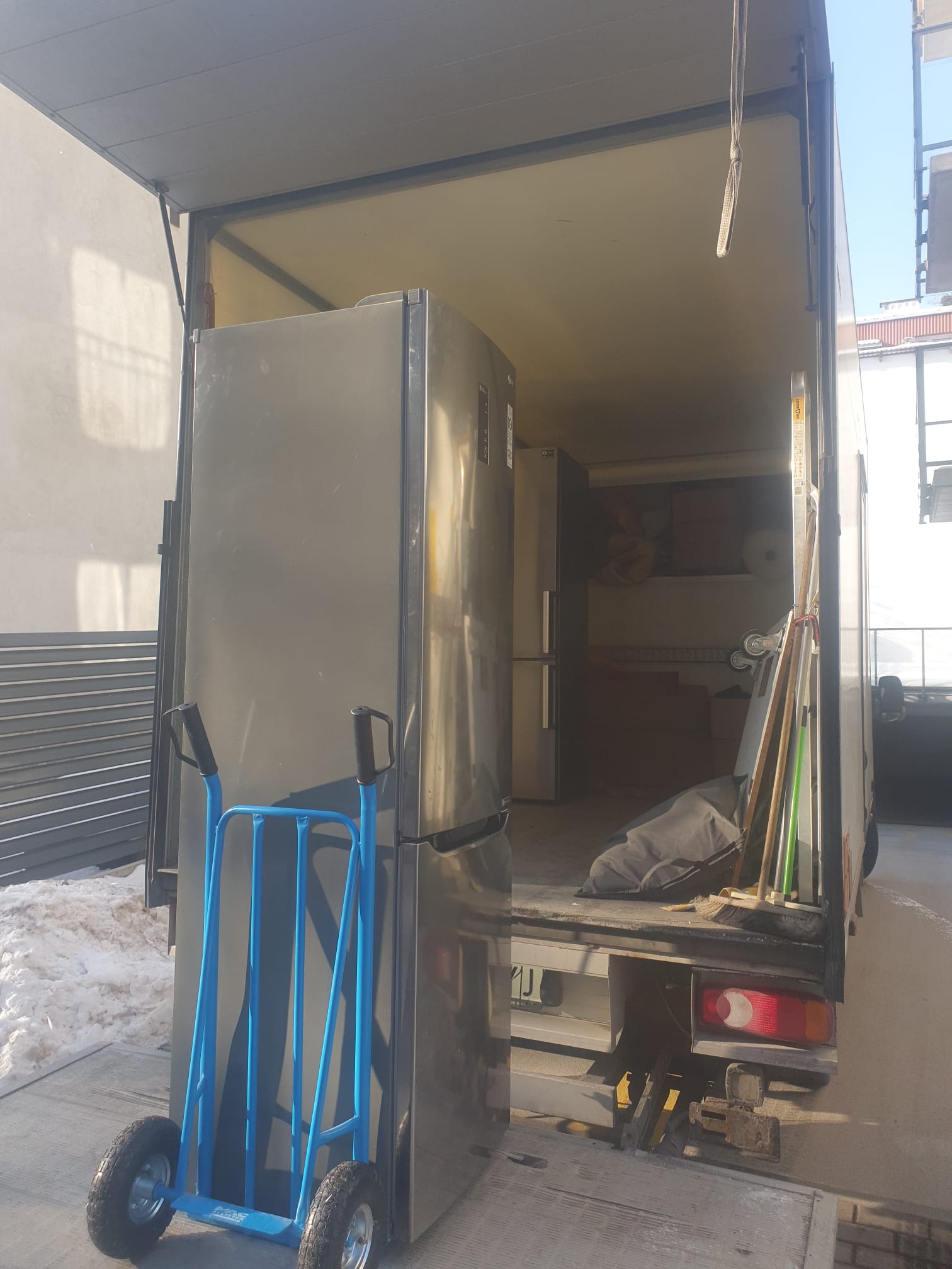 Lodówka na wózku transportowym przy samochodzie przeprowadzkowym